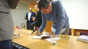 Cesar la Iglesia firmando un ejemplar de su libro En las afueras. Editorial Adarve, Editoriales actuales de España